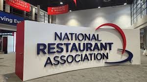 Indoor display of National Restaurant Association logo with large white backdrop and curved red and blue lines.
