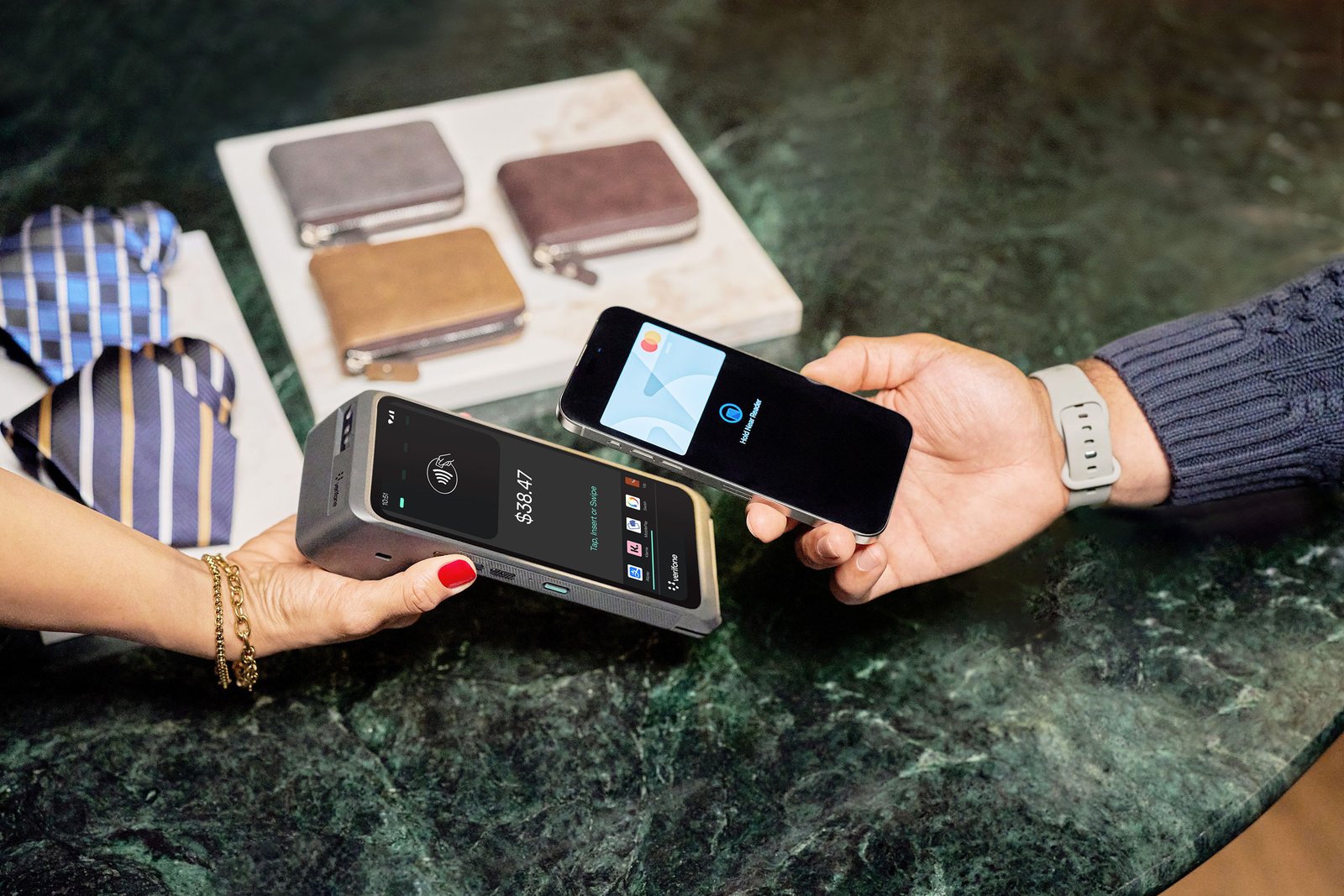Person holding a card reader showing a $38.47 payment, while another person pays using a smartphone with a digital card displayed.